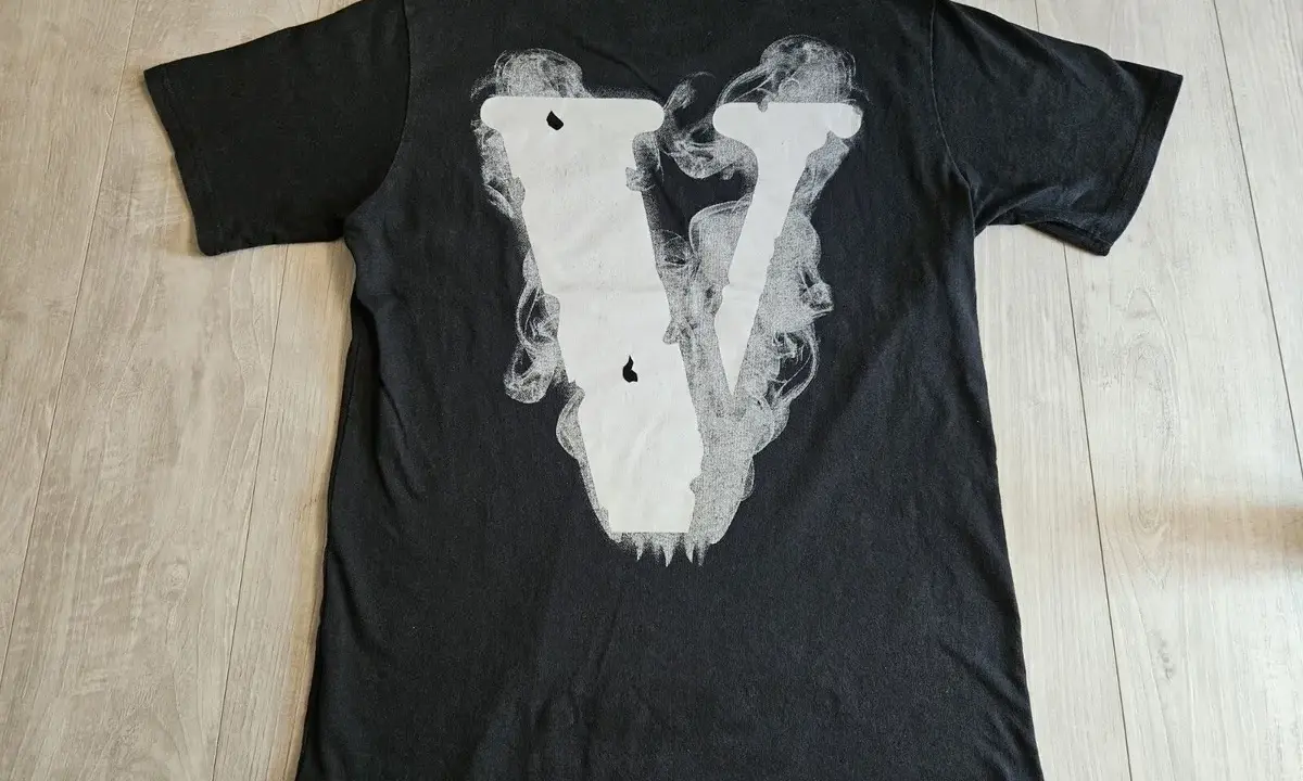 Czarna koszulka z białym, dymiącym logo V. Zastanawiasz się, vlone co to? To właśnie ten styl.