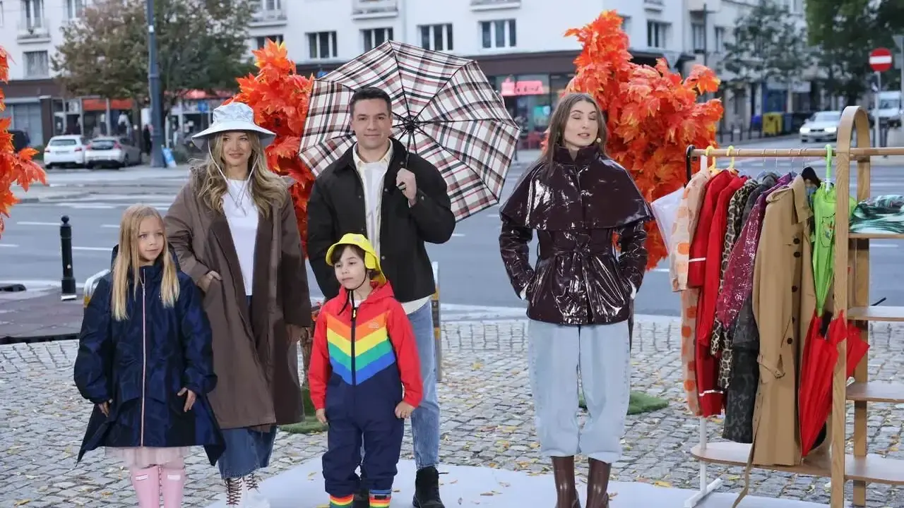 Rodzina prezentuje stylowe stylizacje na deszczowe dni: płaszcze, kalosze i kolorowe parasole.