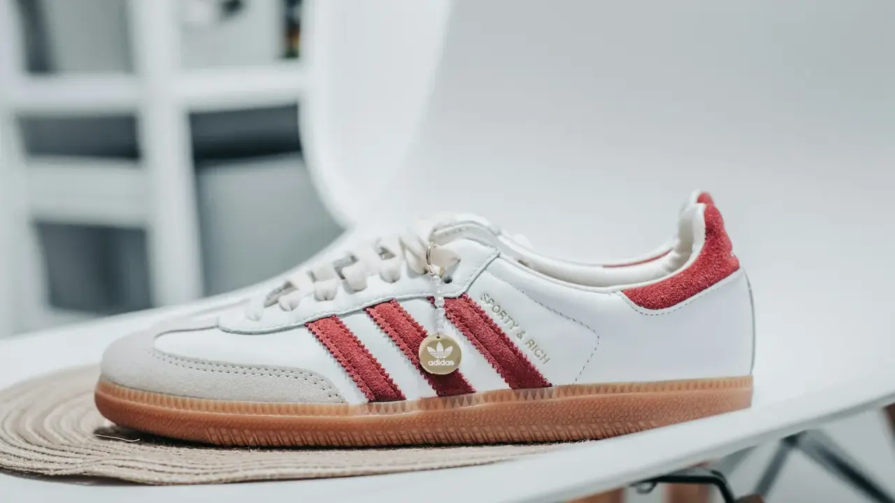 Białe buty adidas Samba z czerwonymi paskami i złotym logo. Sprawdź adidas samba rozmiarówka, by wybrać idealną parę.