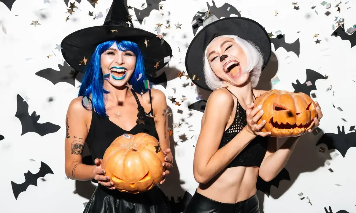 Dwie kobiety w strojach czarownic trzymają dynie. Świetne inspiracje na Halloween!