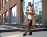 Elegancka kobieta w płaszczu w kolorze camel. Ten odcień pasuje do każdej karnacji, dodając klasy i ciepła.
