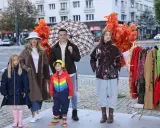 Rodzina prezentuje stylowe stylizacje na deszczowe dni: płaszcze, kalosze i kolorowe parasole.