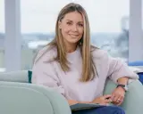 Kobieta w pudrowym swetrze. Kolor lawendowy z jakim kolorem połączyć? Zobacz, jak subtelnie wygląda z jasnym różem.