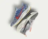 Dwa buty sportowe Nike, jeden niebieski z czerwonymi akcentami, drugi szaro-fioletowy. To przyszłość biegania z Nike Move to Zero.