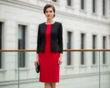 Elegancka kobieta w czerwonej sukience i czarnym żakiecie. Idealna stylizacja, gdy zastanawiasz się, jaki żakiet do czerwonej sukienki pasuje.