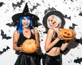 Dwie kobiety w strojach czarownic trzymają dynie. Świetne inspiracje na Halloween!