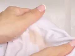 Ręce usuwają tłuste plamy z białej tkaniny, używając mąki ziemniaczanej.