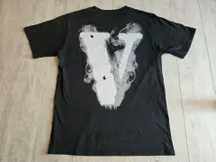Czarna koszulka z białym, dymiącym logo V. Zastanawiasz się, vlone co to? To właśnie ten styl.