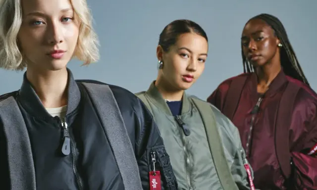 Trzy kobiety w kurtkach bomberkach Alpha Industries. To znana marka odzieży lotniczej.