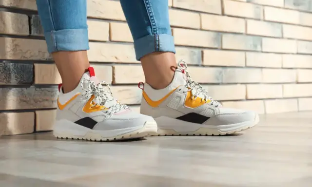 Białe sneakersy z żółtymi i czarnymi akcentami, idealne do jeansów. Czy to HOFF buty? Co to za firma?