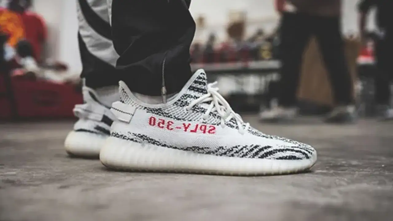 Kultowe buty Yeezy Boost 350 V2 Zebra, symbol wszystkich modeli Yeezy, na stopach fana streetwearu.