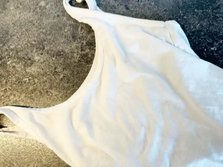 Biała koszulka z widocznymi plamami z banana na materiale.